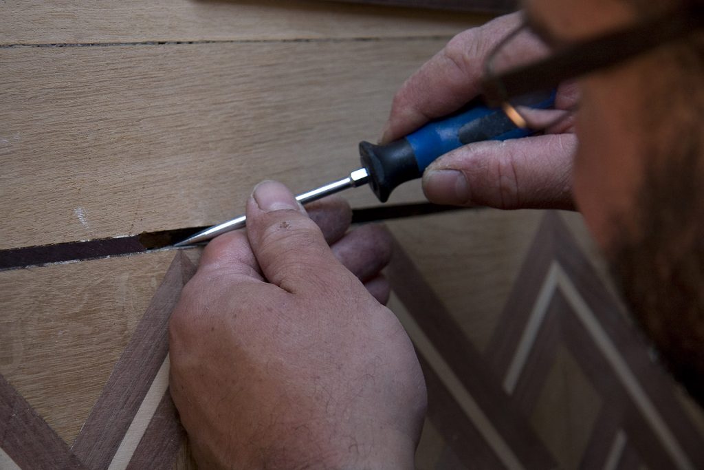 Ouvrier en train de réparer un parquet